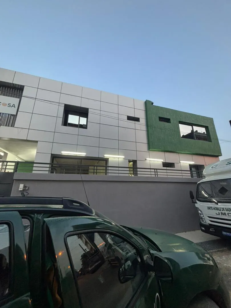 Façade d'un bâtiment portant l'enseigne COSA, vue depuis la rue